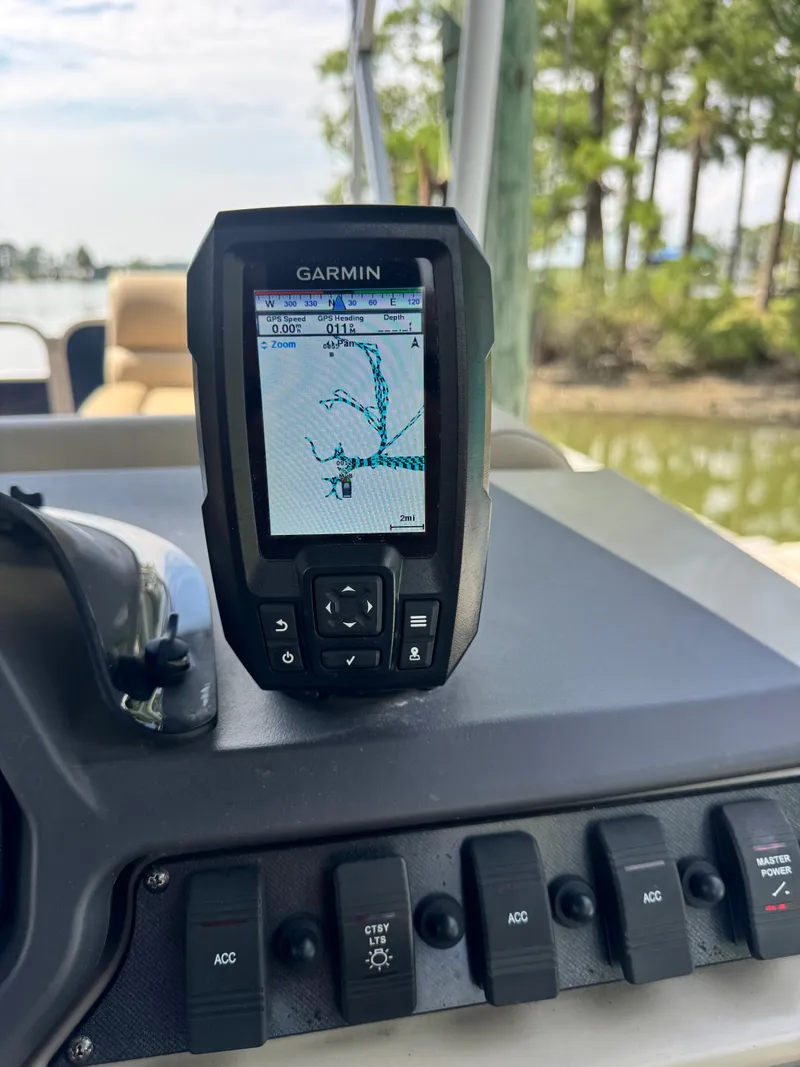 Slide: The Image of A Garmin navigation device is mounted on a boat's dashboard, surrounded by switches. - 12
