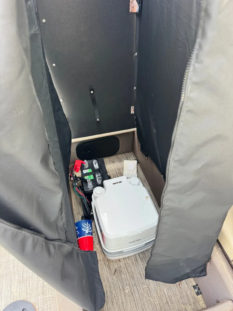 Slide: The Image of A portable toilet system is situated in an enclosed area with a black curtain. - 19