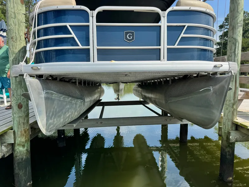 Slide: The Image of A 2022 Godfrey Sweetwater 2286 SFL pontoon boat hovering above the water at a dock. - 1