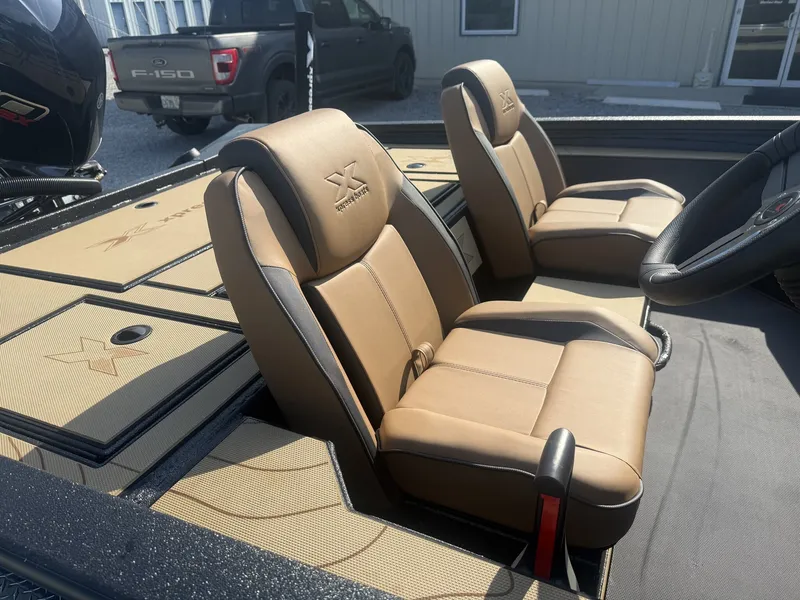 Slide: The Image of Two padded seats in an Xpress H20 Crappie boat, featuring a modern steering wheel. - 7