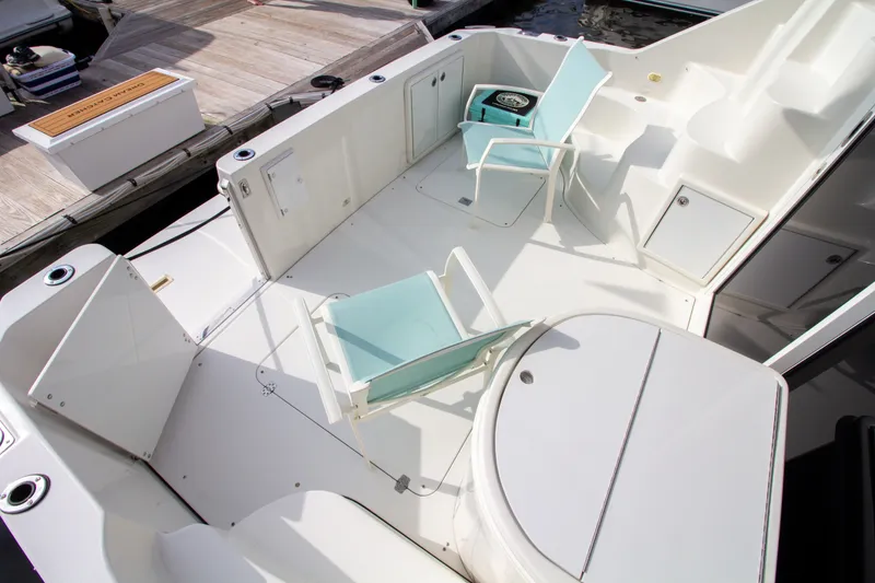 Slide: The Image of The image shows the spacious aft deck of a 2006 Carver 33 Super Sport with two blue chairs. - 26