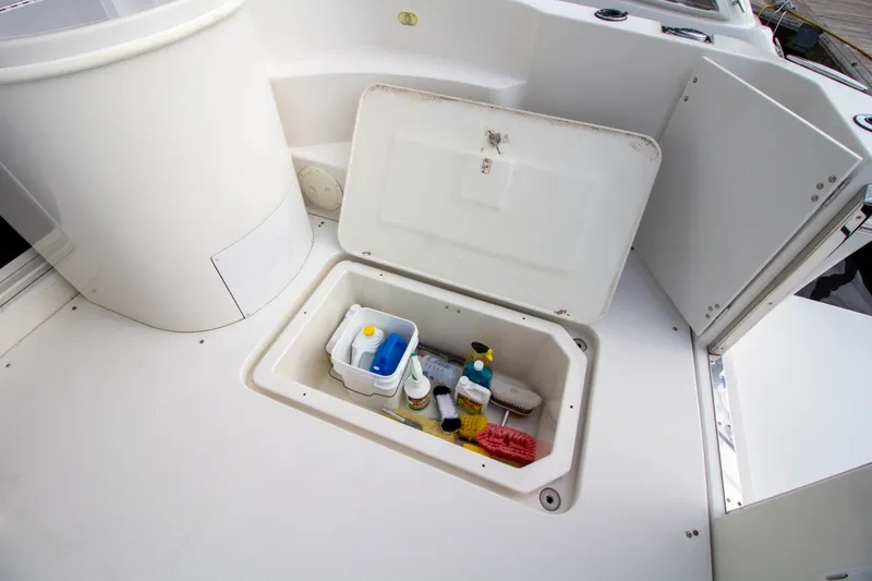 Slide: The Image of An open storage compartment on a boat with cleaning supplies and brushes. - 33