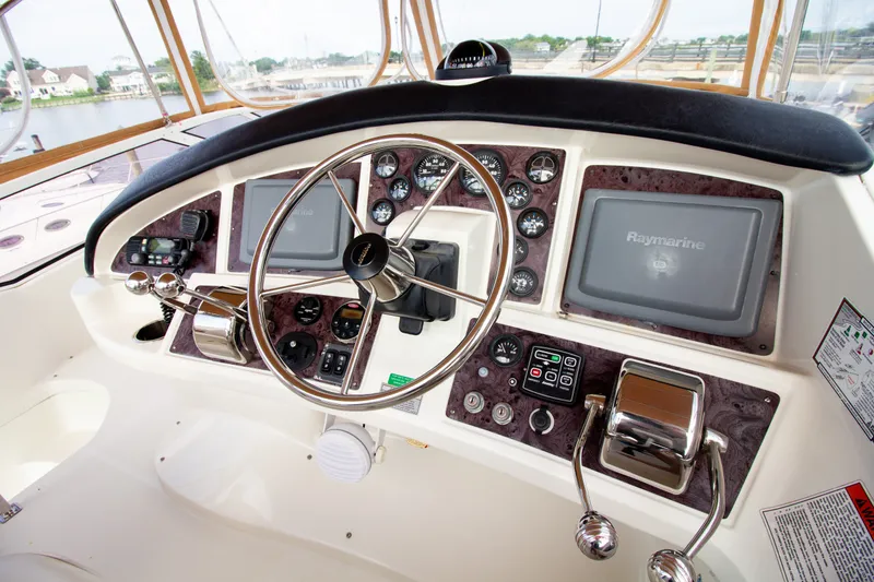 Slide: The Image of The cockpit of the 2006 Carver 33 Super Sport features a sleek steering wheel and modern instruments. - 42