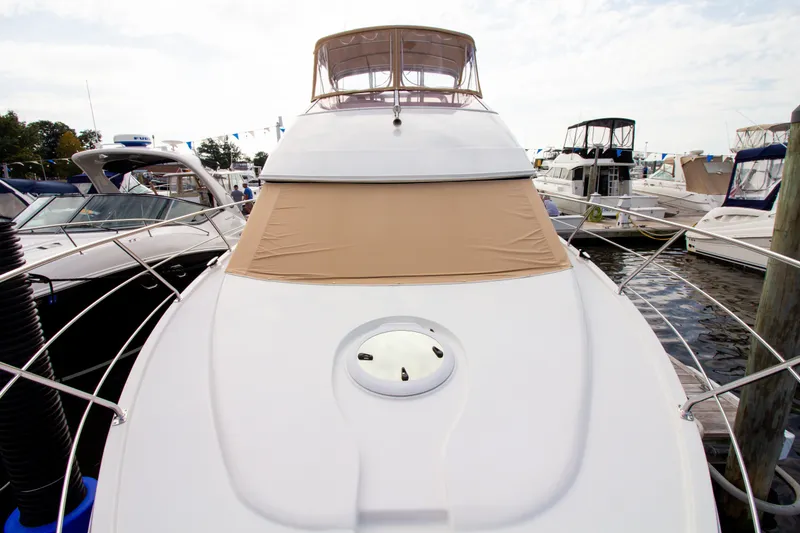 Slide: The Image of The 2006 Carver 33 Super Sport is docked, featuring a beige sunshade and sleek design. - 38