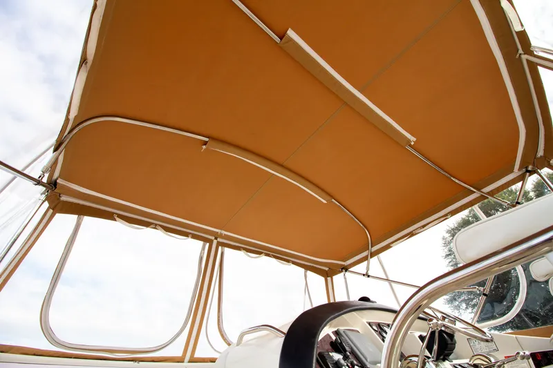 Slide: The Image of The image shows the canopy of a 2006 Carver 33 Super Sport with a beige fabric roof. - 49
