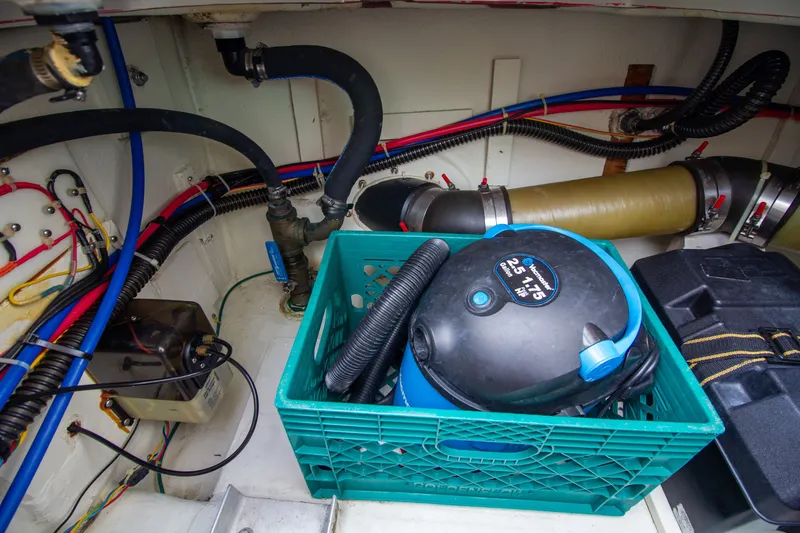 Slide: The Image of The engine room of a 2006 Carver 33 Super Sport with hoses and a vacuum cleaner. - 32