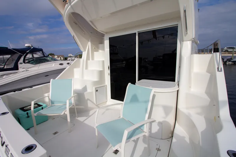 Slide: The Image of The image shows the stern of a 2006 Carver 33 Super Sport with two blue chairs. - 23