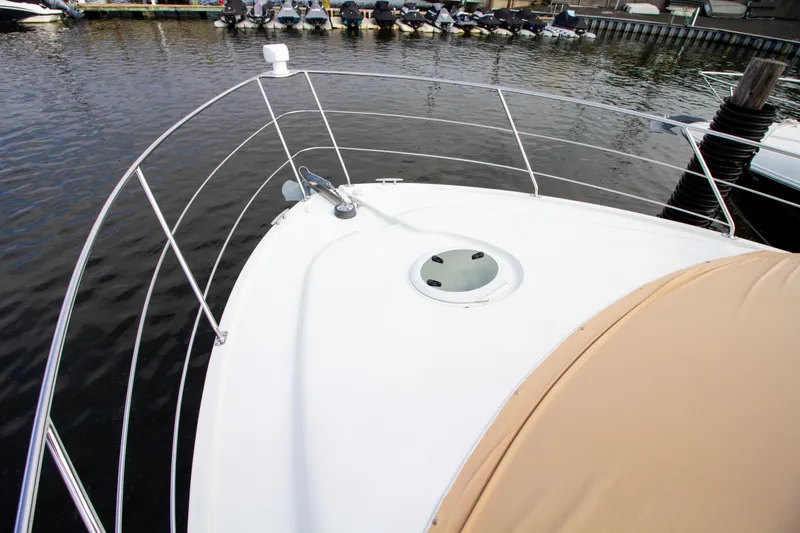 Slide: The Image of The 2006 Carver 33 Super Sport is docked. The foredeck with railing is visible. - 36