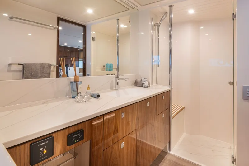 Slide: The Image of Luxurious bathroom with double sinks, wooden cabinets, and a spacious shower in a yacht. - 15