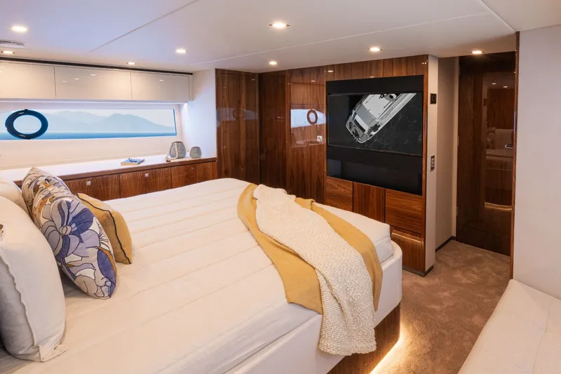 Slide: The Image of Luxurious cabin with a large bed, wooden furnishings, and a window overlooking the sea. - 14