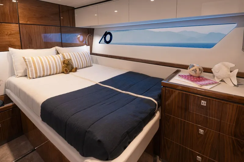 Slide: The Image of Luxurious cabin with a large bed, wooden furniture, and a window with a sea view. - 19