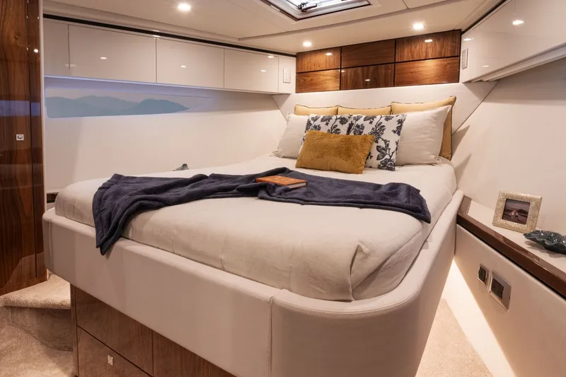 Slide: The Image of The image shows a luxurious cabin with a large bed, decorative pillows, and wood paneling. - 16