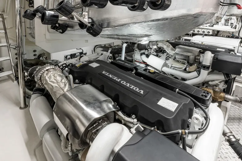 Slide: The Image of The engine room features a Volvo Penta engine with shiny metal components and pipes. - 22