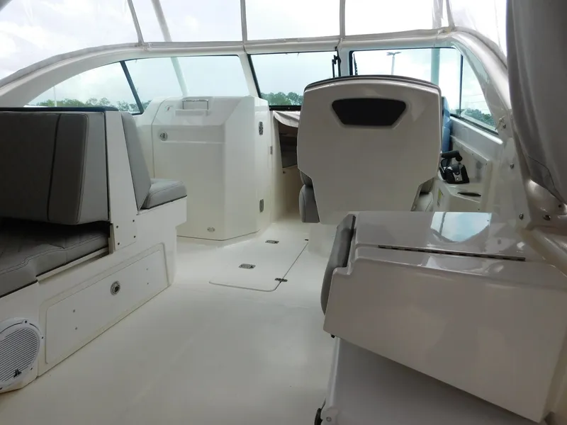 Slide: The Image of The image shows the cockpit of a 2023 Pursuit DC 246 Dual Console boat with gray seating and a helm station. - 13