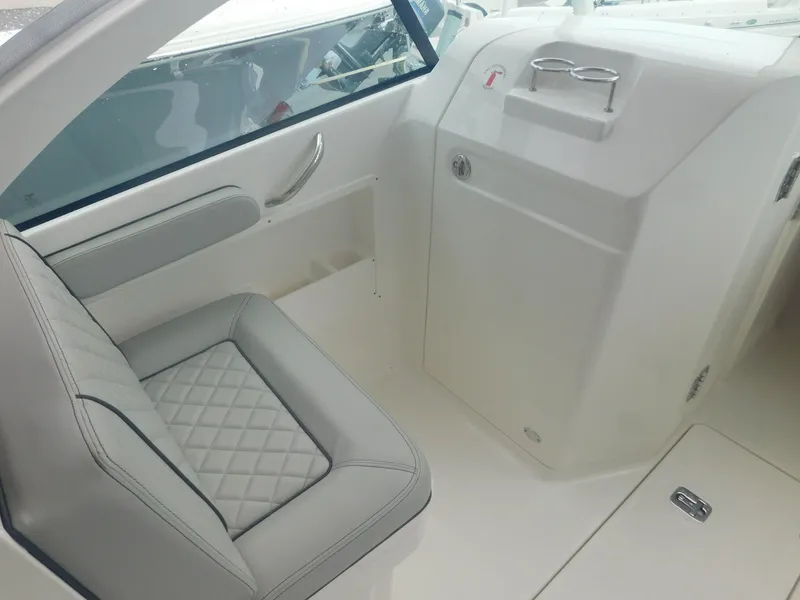 Slide: The Image of Interior of a 2023 Pursuit DC 246 Dual Console with cushioned seating and helm console. - 5