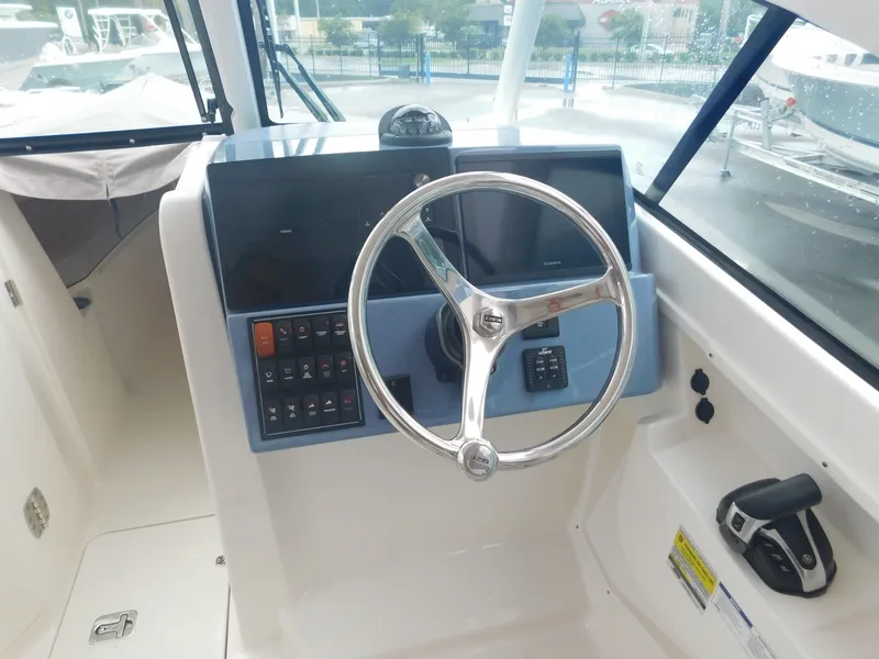 Slide: The Image of The image shows the helm of a 2023 Pursuit DC 246 Dual Console boat. - 4