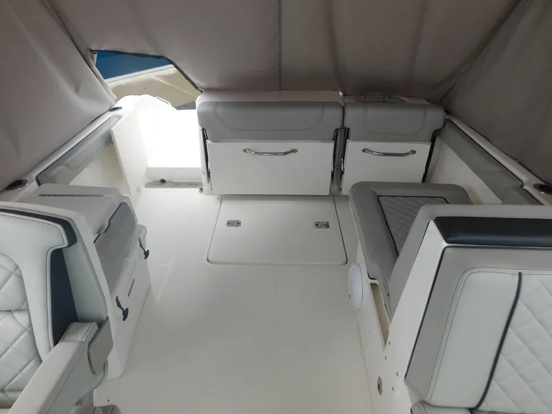Slide: The Image of The image shows the cockpit of a 2023 Pursuit DC 246 Dual Console boat with gray upholstery. - 9