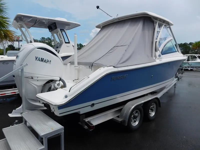 Slide: The Image of A 2023 Pursuit DC 246 Dual Console boat on a trailer with a gray cover and Yamaha engine. - 15