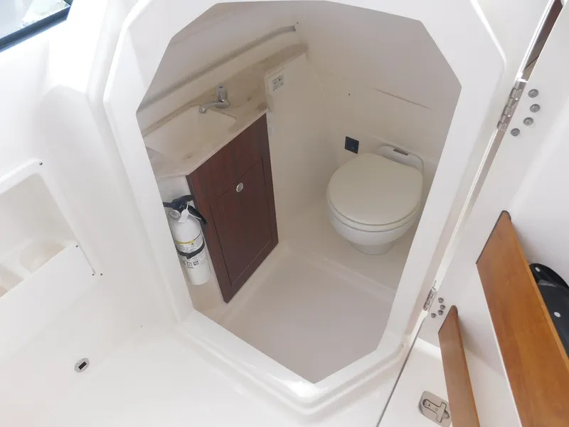 Slide: The Image of The image shows a compact boat bathroom with a toilet, sink, and storage cabinet. - 6