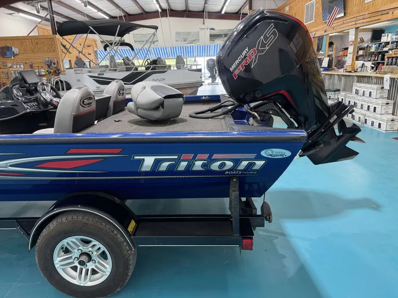 Slide: The Image of A blue 2017 Triton 18CTX with a Mercury engine on a trailer in a warehouse. - 8