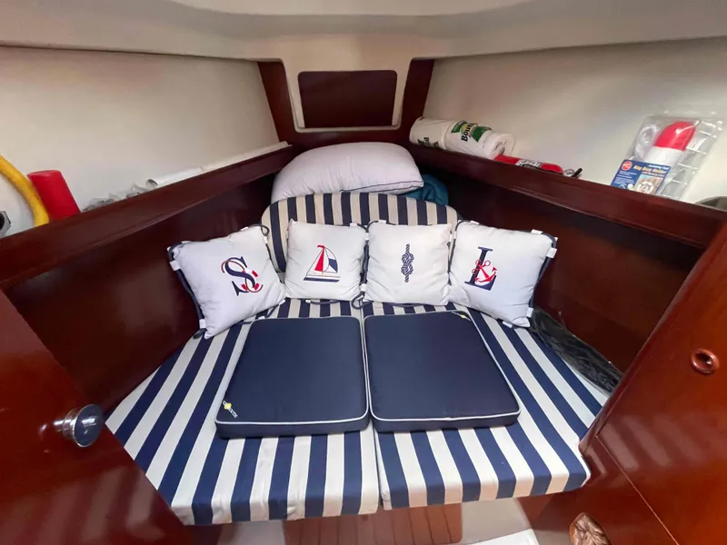 Slide: The Image of Cozy cabin interior of 2004 Beneteau 361 sailboat with nautical-themed cushions. - 6