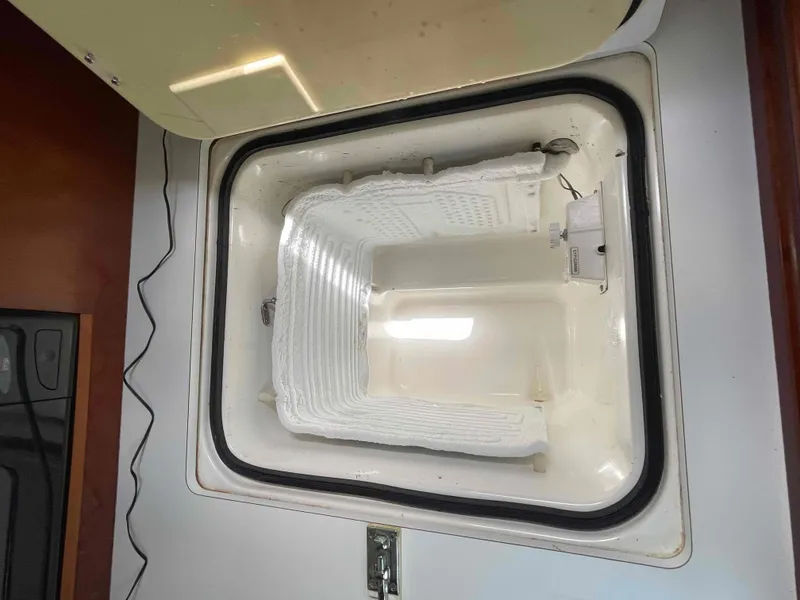 Slide: The Image of Open refrigerator compartment in a 2004 Beneteau 361 sailboat, showing interior details. - 14