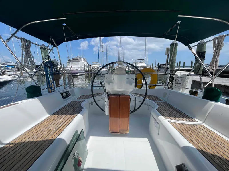 Slide: The Image of 2004 Beneteau 361 sailboat cockpit with steering wheel, docked at marina under blue sky. - 20