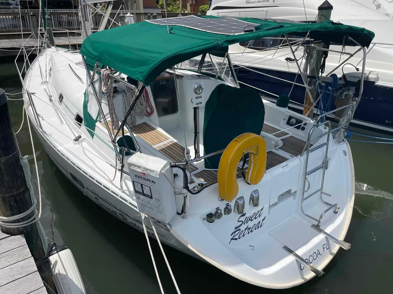 Slide: The Image of 2004 Beneteau 361 sailboat docked, featuring green canopy and safety equipment. - 23