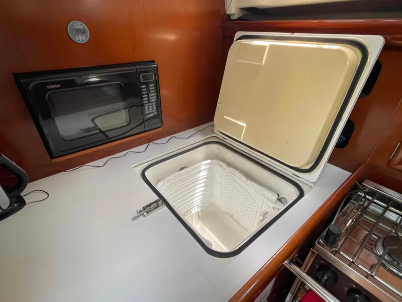 Slide: The Image of Galley of 2004 Beneteau 361 yacht with open fridge and microwave. - 13