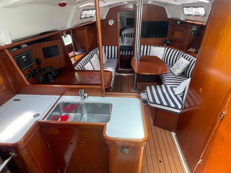 Slide: The Image of Interior of 2004 Beneteau 361 sailboat with striped seating and wooden finishes. - 11