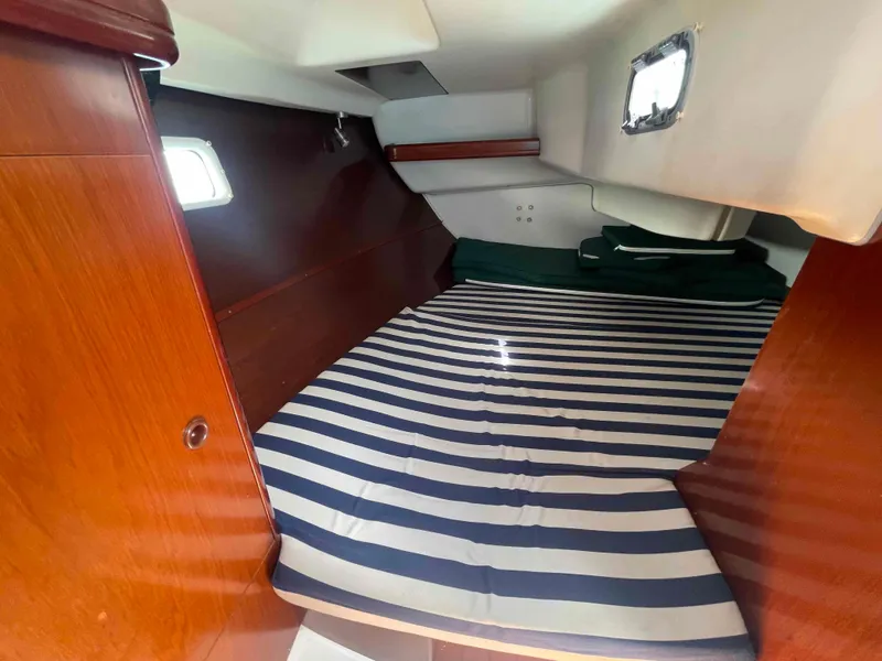Slide: The Image of Cozy cabin interior of 2004 Beneteau 361 sailboat with striped bedding. - 19