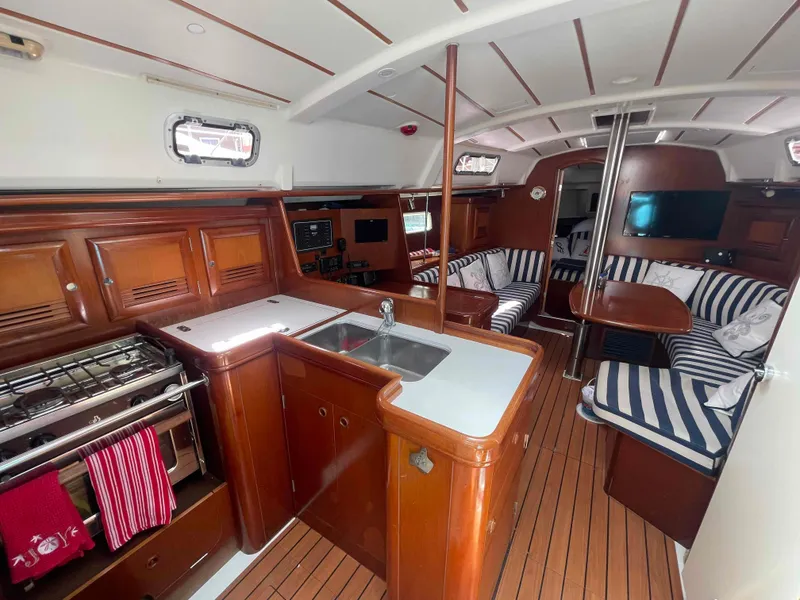 Slide: The Image of Interior of 2004 Beneteau 361 sailboat with wood finish and striped seating. - 50