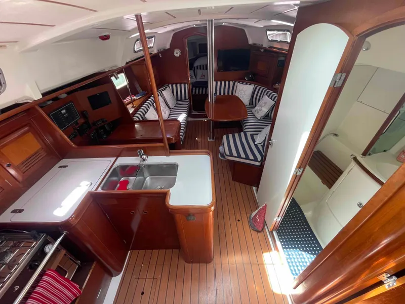 Slide: The Image of Interior of 2004 Beneteau 361 sailboat with kitchen, seating, and wooden flooring. - 18