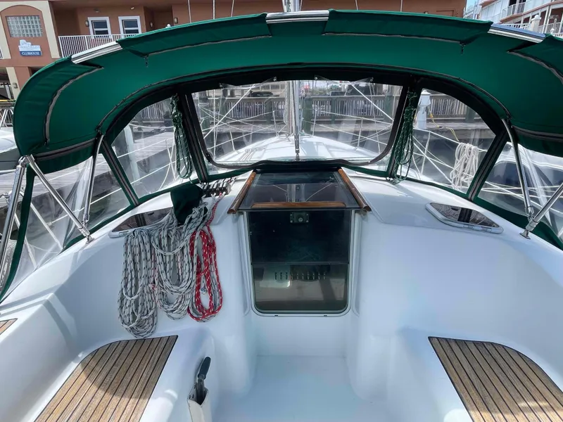 Slide: The Image of 2004 Beneteau 361 sailboat cockpit with green canopy and neatly coiled ropes. - 21