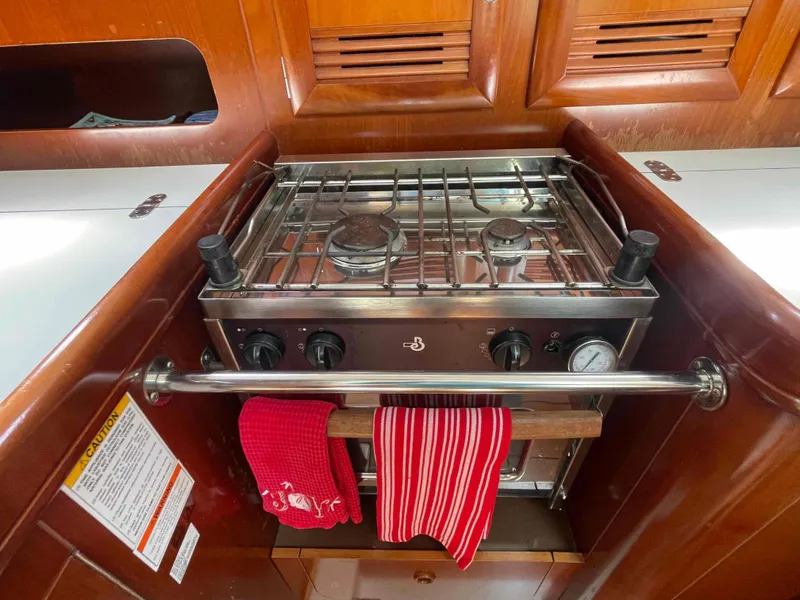 Slide: The Image of Galley stove in 2004 Beneteau 361 sailboat with red towels hanging. - 16