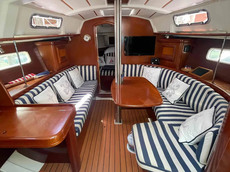 Slide: The Image of Interior of 2004 Beneteau 361 sailboat with striped seating and wooden finishes. - 3