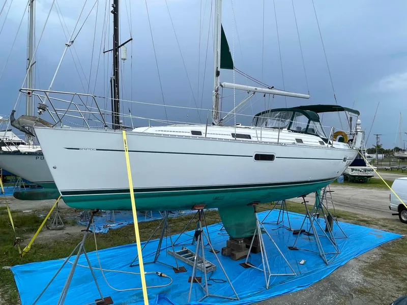 Slide: The Image of 2004 Beneteau 361 sailboat on stands, blue tarp, overcast sky. - 30