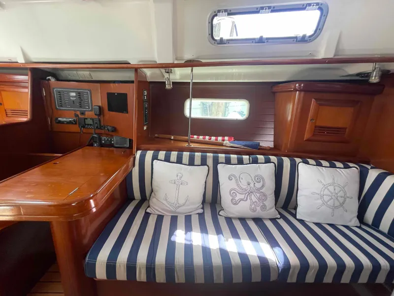 Slide: The Image of Interior of 2004 Beneteau 361 sailboat with striped seating and nautical-themed cushions. - 48