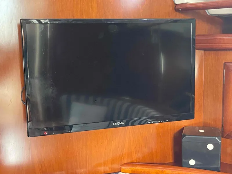 Slide: The Image of Flat-screen TV mounted on wooden interior of 2004 Beneteau 361 sailboat. - 49