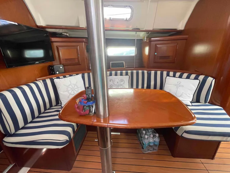 Slide: The Image of Interior of 2004 Beneteau 361 sailboat with striped seating and wooden table. - 17