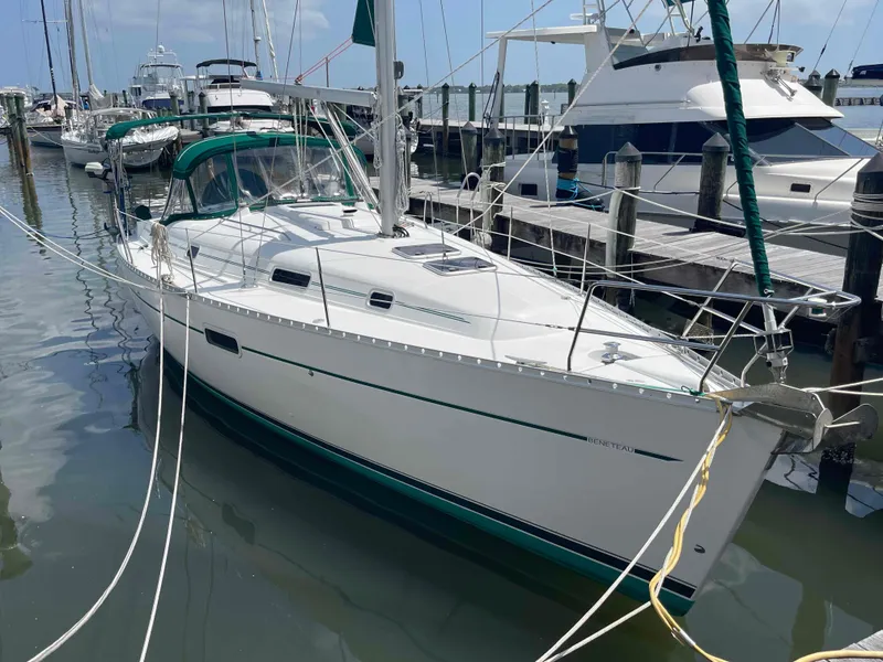 Slide: The Image of 2004 Beneteau 361 sailboat docked at marina, featuring sleek white hull and green accents. - 32