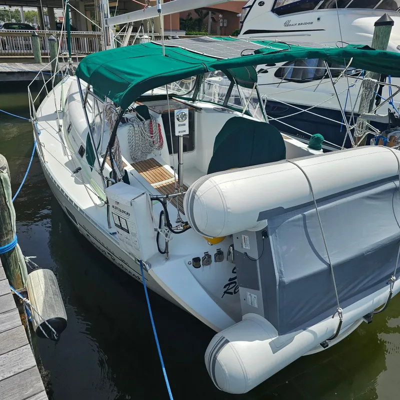 Slide: The Image of 2004 Beneteau 361 sailboat docked with green canopy and inflatable dinghy attached. - 24