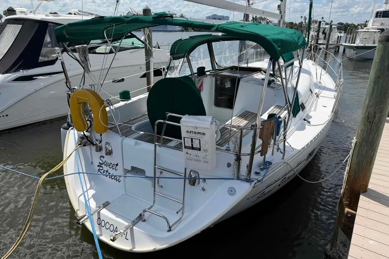 Slide: The Image of 2004 Beneteau 361 sailboat docked, featuring green canopy and "Sweet Retreat" name on stern. - 26