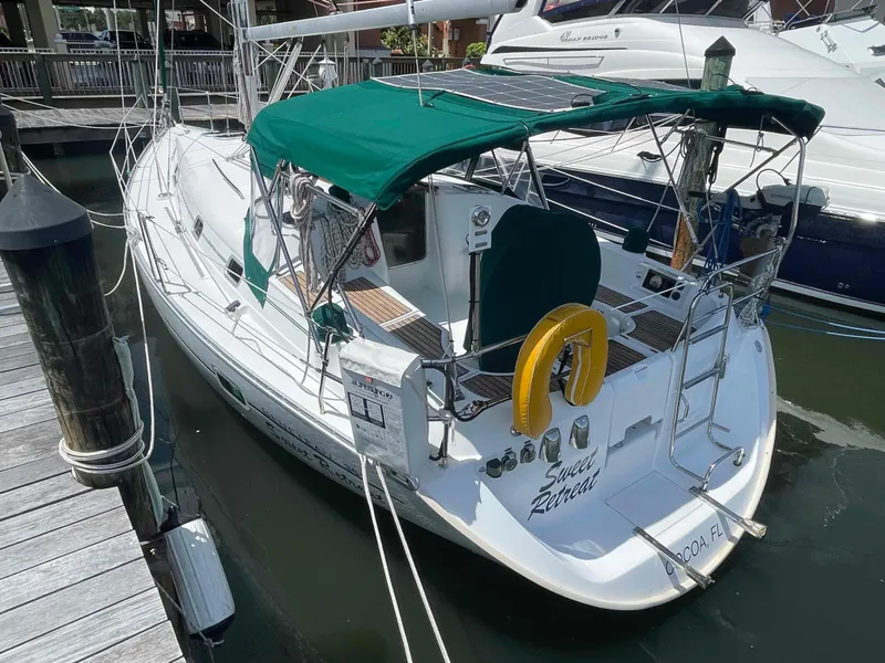 Slide: The Image of 2004 Beneteau 361 sailboat docked, featuring green canopy and safety equipment. - 36