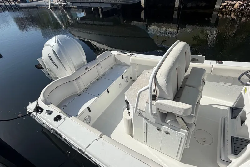 Slide: The Image of 2022 Sea Hunt Ultra 239SE boat interior with Yamaha outboard engine, docked on calm water. - 52