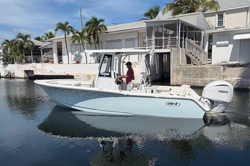 Slide: The Image of 2022 Sea Hunt Ultra 239SE boat with Yamaha engine docked near waterfront homes. - 2
