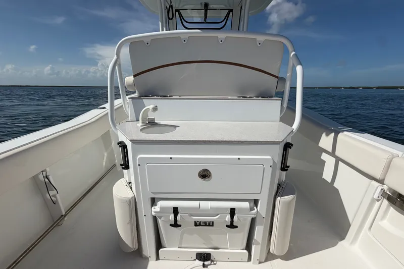 Slide: The Image of 2022 Sea Hunt Ultra 239SE boat interior with console and storage on open water. - 41