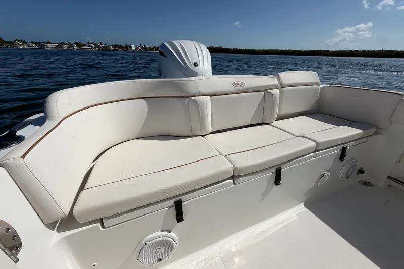 Slide: The Image of 2022 Sea Hunt Ultra 239SE boat with comfortable seating, on a calm water backdrop. - 39