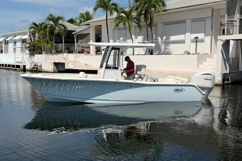 Slide: The Image of 2022 Sea Hunt Ultra 239SE boat docked near waterfront homes, featuring Yamaha engine. - 5