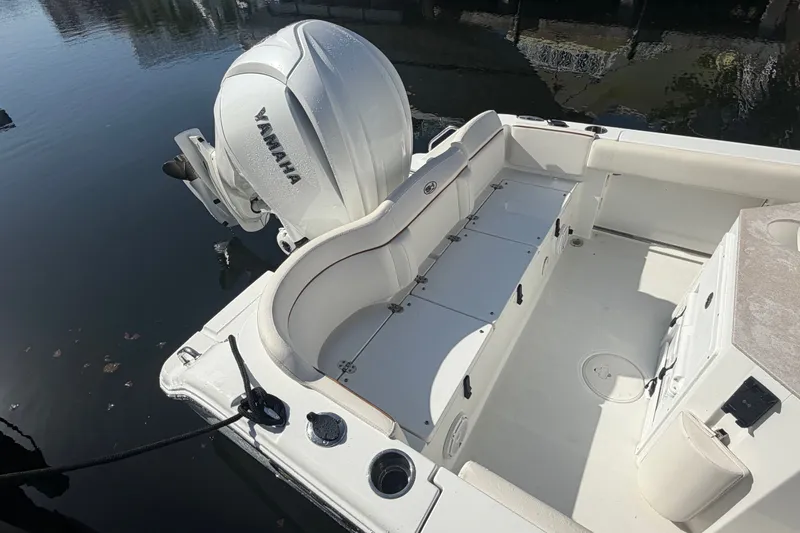 Slide: The Image of 2022 Sea Hunt Ultra 239SE boat interior with Yamaha engine, docked on calm water. - 53
